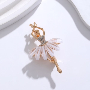 Macro view of gold ballet dancer brooch featuring sparkling crystals and white pearlescent skirt