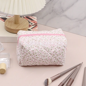 Detail of pink floral quilted makeup bag featuring smooth zipper and soft fabric texture