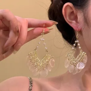Detail of vintage champagne gold tassel earrings with pearls and translucent discs