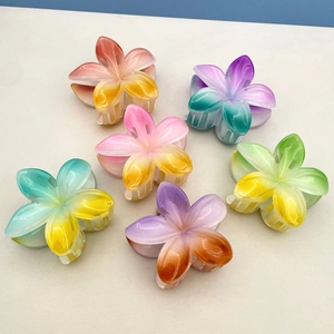 Close-up of set of six gradient frangipani hair claw clips with translucent finish
