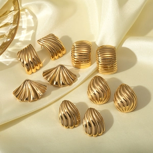 Golden 18K gold plated stainless steel textured earrings on elegant beige silk fabric