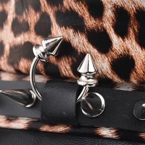 Macro detail of silver horseshoe ring with sharp spikes on punk leopard background