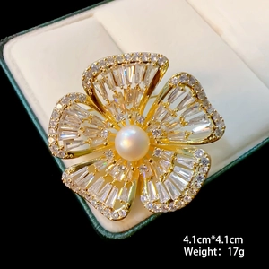 Macro shot of 4.1cm floral lotus brooch with natural pearl and zircon in golden finish
