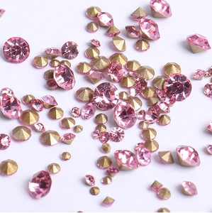 Detailed macro shot of sparkling pink rhinestones with gold pointed base for nail art DIY
