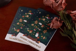 Detail of Christmas cards with a festive tree design on a dark wood background