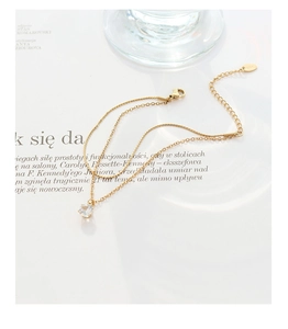 Détail de la chaîne dorée double couche avec pendentif zircon rond et fermoir mousqueton