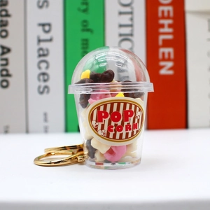 Macro shot of miniature popcorn cup keychain with colorful food charms and metal ring
