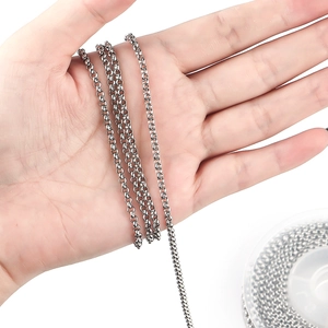 Close-up of shiny silver stainless steel pearl chain held by hand for DIY jewelry making