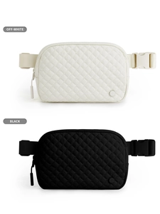Detailed macro view of quilted nylon waist bags in off-white and black with adjustable straps
