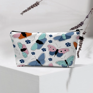 Detail of white makeup bag with butterfly floral prints and black zipper on a display stand