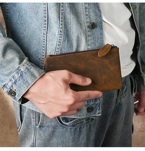 Detailed view of vintage brown crazy horse leather zipper pocket on slim wallet bag
