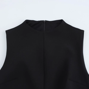 Close-up of minimalist black sleeveless dress showing round neck and invisible back zipper
