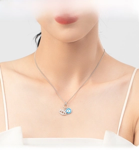 Detail of s925 silver Evil Eye double pendant necklace on female model neck