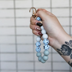 Detail of floral silicone bead keychain bracelet with rose gold clasp on wrist