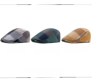 Dettaglio di tre berretti piatti in cotone a quadretti nei colori blu, verde e arancione