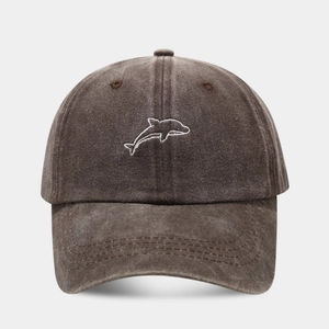 Close-up of dolphin embroidery on washed cotton baseball cap with vintage texture