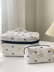 Detail of quilted bow cosmetic bags showing texture and 'today mood' woven label