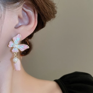 Détail de boucles d'oreilles papillon dégradé avec perles et pendentif rose