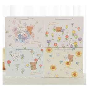 Set of four cartoon gift bags with cute bear and floral patterns in pastel colors