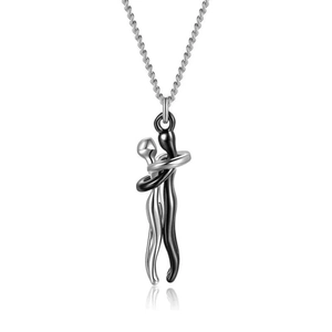 Macro shot of silver and black metal lovers hugging pendant on a link chain necklace