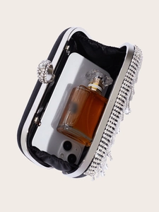 Internal view of black tassel clutch bag showing space for smartphone and perfume bottle