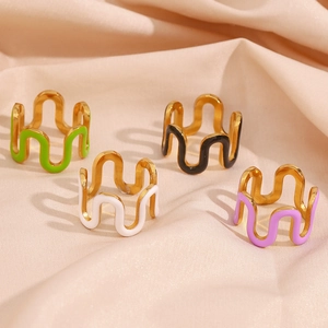 Detail of colorful enamel wave rings in green black white and purple on silk