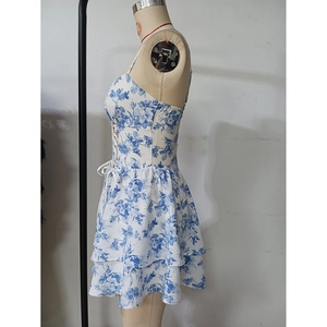 Détail de la robe à fleurs bleu et blanc montrant le buste lacé et l'ourlet à volants