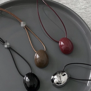 Minimalist wax cord necklaces with oval pebble pendants in burgundy, brown, black, and silver