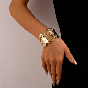 Détail d'un bracelet manchette doré en forme de feuille avec texture de veines réelle