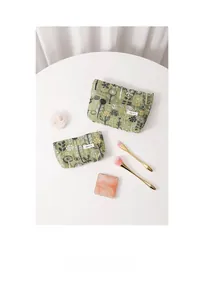 Flat lay of floral cotton linen makeup bags in two sizes with botanical embroidery