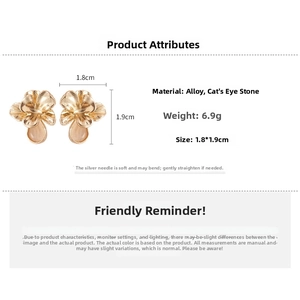 Detail view of gold flower earrings with opal stone inlay showing size 1.8cm x 1.9cm