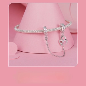 Close-up of S925 sterling silver snake chain bracelet with pink heart charms and lock pendant