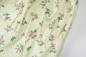 Close-up of yellow floral fabric showing pink flower patterns and pleated texture detail