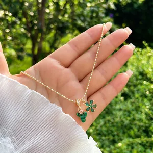 Dettaglio della collana con sfere in oro 18K, ciondolo a cactus e fiore in cristallo