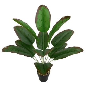 Detail view of artificial bird of paradise plant with large green leaves in a black pot