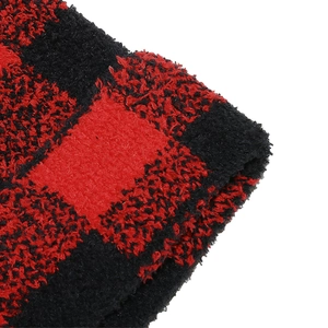 Macro view of the soft red and black buffalo plaid fabric texture on winter knit beanie