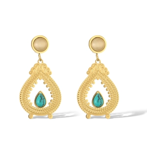 Detailed shot of gold drop earrings featuring intricate patterns and turquoise stone inlay