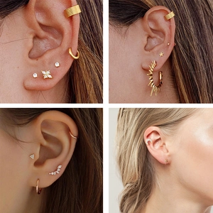 Detail showing a gold earring set with star, moon and floral studs on a model ear