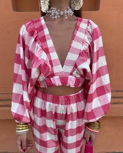 Detail of pink plaid two-piece set featuring V-neck puff sleeve top and matching pants