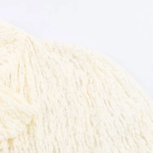 Detailed close-up of white lace fabric texture and stitching on women's romper