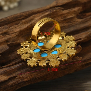 Detailed view of bohemian gold flower ring with blue finish on bark background