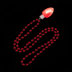Collana con ciondolo a lampadina di Natale rossa luminosa e perline rosse su fondo nero