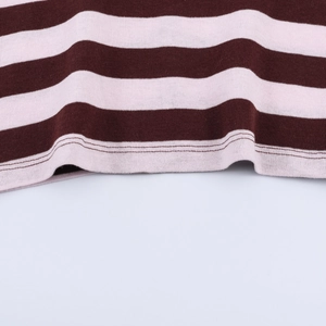 Detailed close-up showing the precise double-needle hem on a striped knit sweater