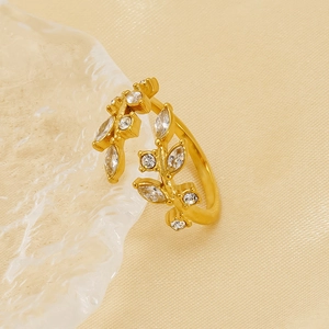 Elegant gold leaf open ring with marquise cubic zirconia on a warm aesthetic background