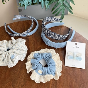Floral and blue fabric hair accessories set including headbands and scrunchies on wood