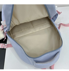 Detailed macro view of the interior compartments and lining of the pink and blue backpack