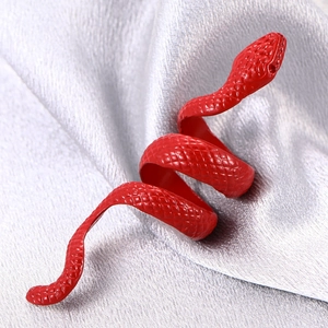 Macro shot of bright red snake ring featuring detailed scale texture on silver silk fabric