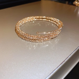Dettaglio del bracciale avvolgente multistrato in oro rosa con trama di perline