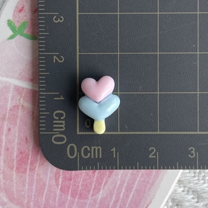 Detailed view of mini glowing resin ice cream charms on a measuring mat for size reference