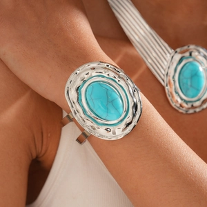 Detail of silver wavy metal bracelet and necklace set with oval turquoise stones
